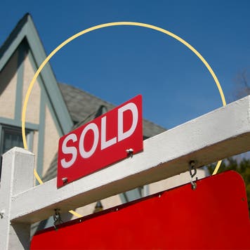 upward view of home with red sold sign outside