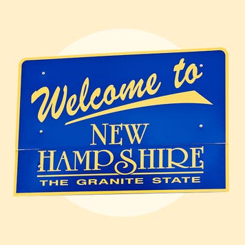 A blue sign with gold lettering saying "Welcome to New Hampshire The Granite State"