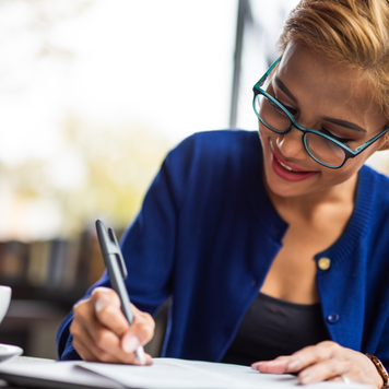 Young Indonesian woman writing down notes for next business meeting.