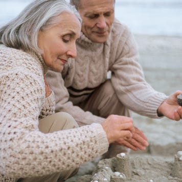 Senior couple making a sandcastle