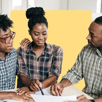 A Black couple and loan underwriter look at a contract.