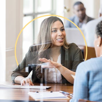 Two people talking in front of a computer