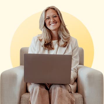 design image of katie kelton on a couch with her laptop on her lap