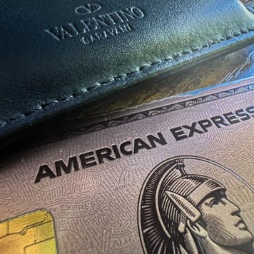 American Express card laying on table next to a wallet