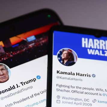 Two smartphones displaying the X accounts of Donald Trump and Kamala Harris.