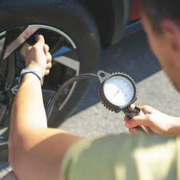 Rear view of man inflating tires of his car