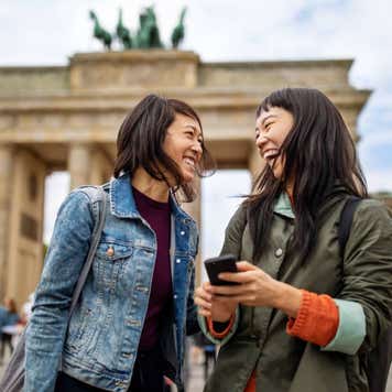 Cheerful friends standing against Brandenburg Gate