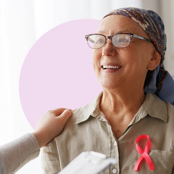 A cancer patient with a shawl over their bald scalp speaking with a doctor