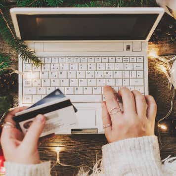 Woman using credit card to shop online, close up