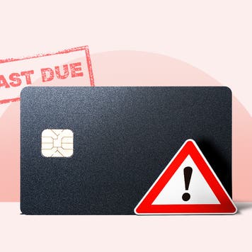 Credit card with a past-due stamp and warning sign on it.