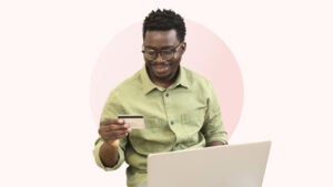 Illustration of young man holding credit card and laptop