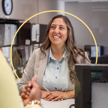 2 people at counter at a business speaking with each other