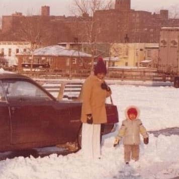 Aged photo of young girl with parent on snowy street