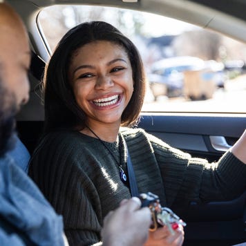 Father handing car keys to teenage daughter