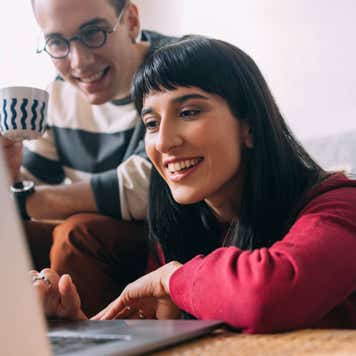 two people looking at computer smiling