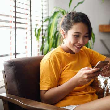 Woman using her smart phone at home