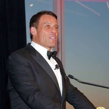Tony Robbins speaks at a podium.