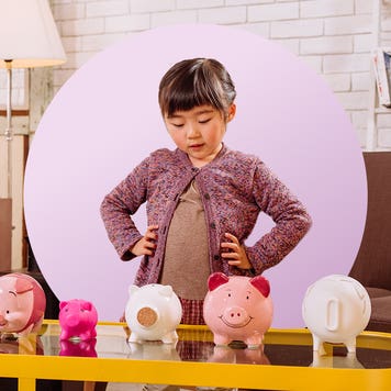 Design element of a child standing in front of a table, looking at several piggy banks