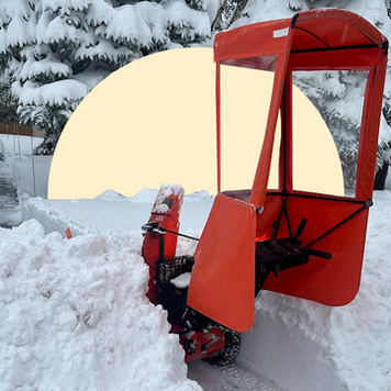 snow blower in snowy front yard
