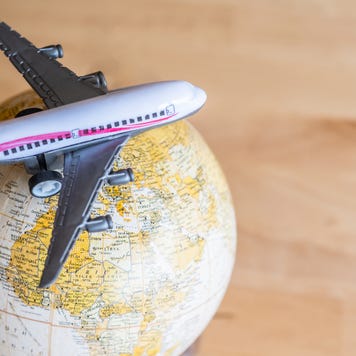 A miniature airplane sitting on a vintage globe