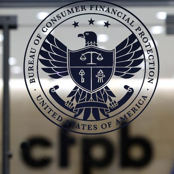 A picture of the CFPB logo on the glass door leading into a building.