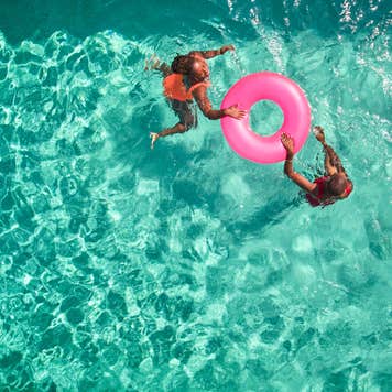 Overhead picture of two people with a innertube in a pool