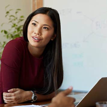 Business women discussing project at table in modern office