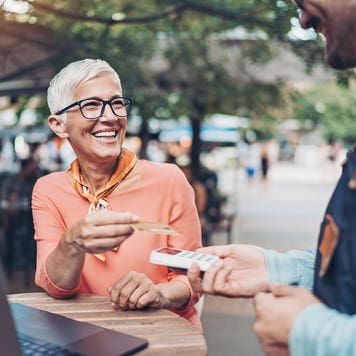 Smiling senior woman making a contactless payment