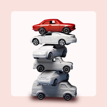 stack of cars on pink background