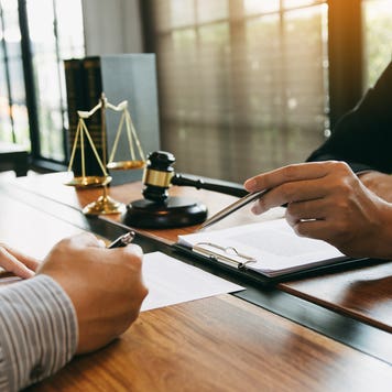 Lawyer is explaining about the wrongdoing laws regarding fraud to the client at the office.