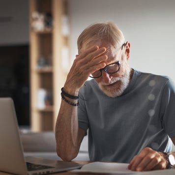 An elderly white man with an anxious expression reviews paperwork.
