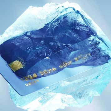 Digital generated image of credit card frozen against light blue background. Financial and banking concept.