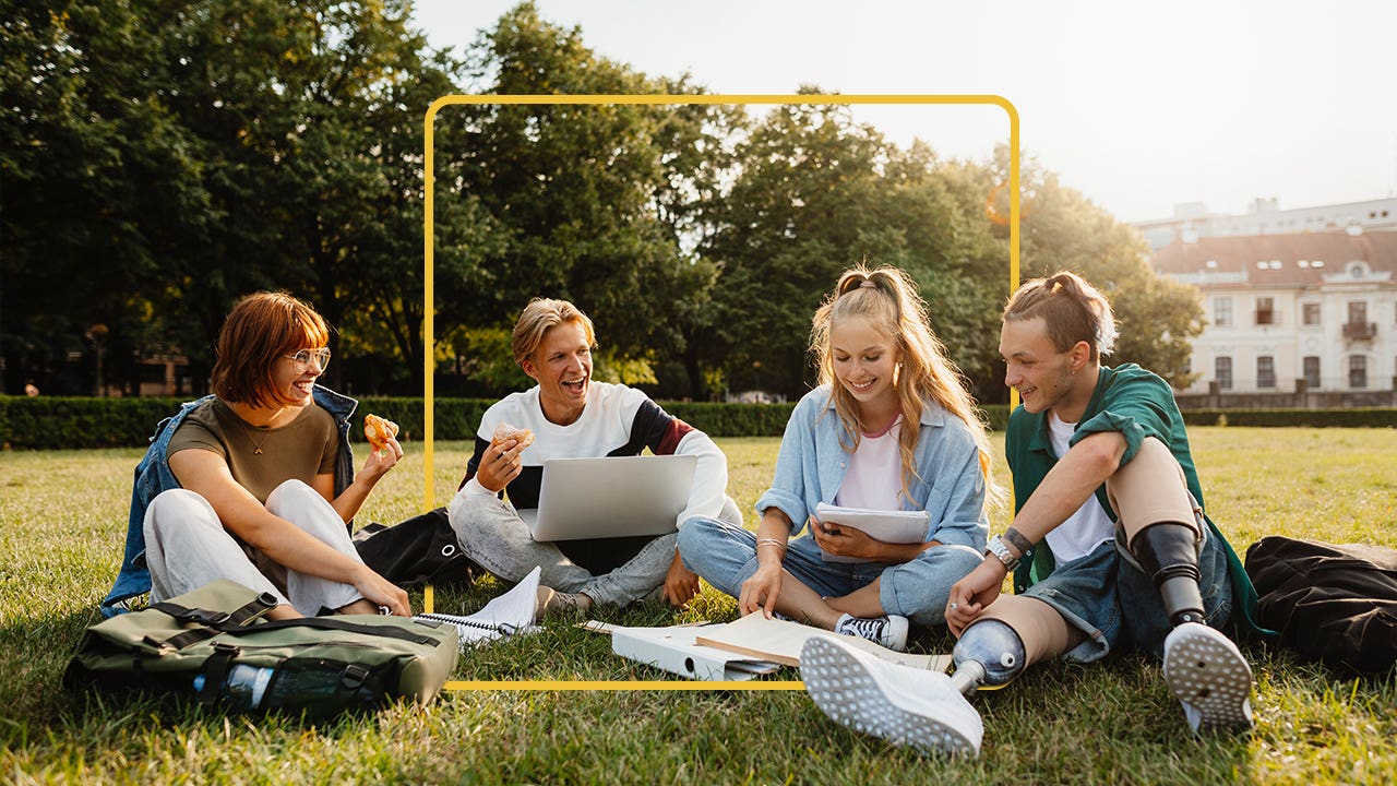 Four students sitting on the quad, studying together and enjoying each other's company
