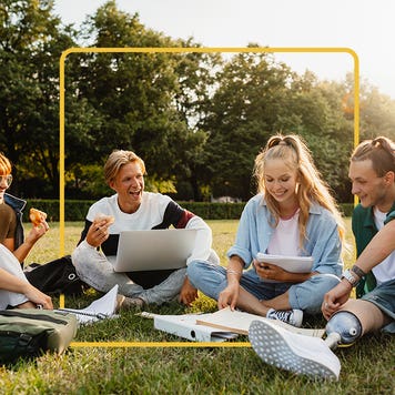 Four students sitting on the quad, studying together and enjoying each other's company