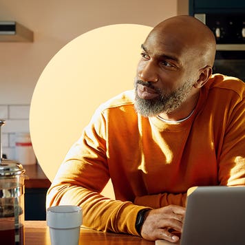 design image of a man smiling and looking to the side from his laptop