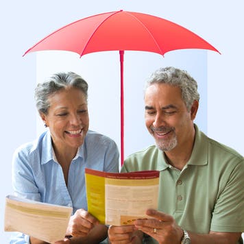 Mature couple reading a document under an umbrella alluding to life insurance protection