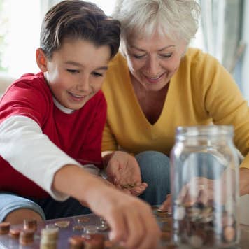 Older woman and child putting pennies in a jar