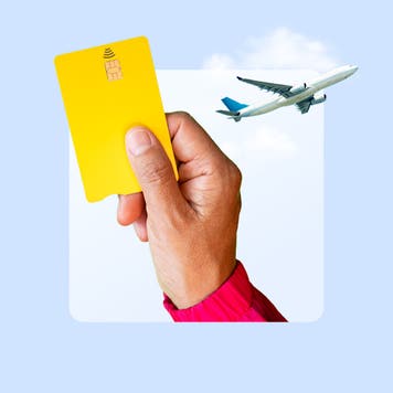 An illustration of a hand holding a credit card and a plane