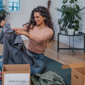 A young woman inspects the clothes she is going to donate.