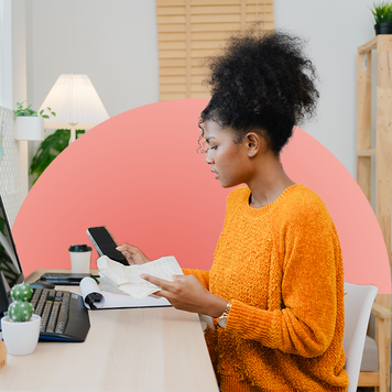 Young woman sits at her home office working on her finances.