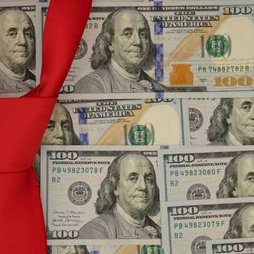 Conceptual image of several $100 bills arranged as wallpaper with a red necktie suggesting Donald Trump.