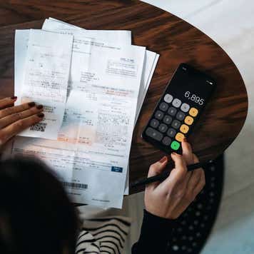 Overhead view of young Asian woman managing personal banking and finance at home.
