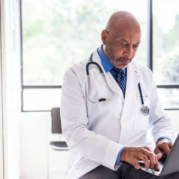 Doctor looking at laptop.