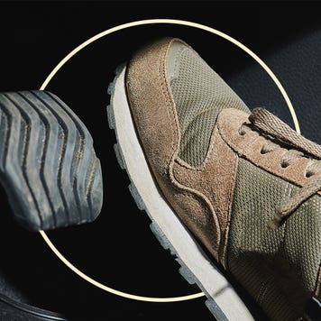 closeup of car driver's green and tan shoe hovering over brake pedal