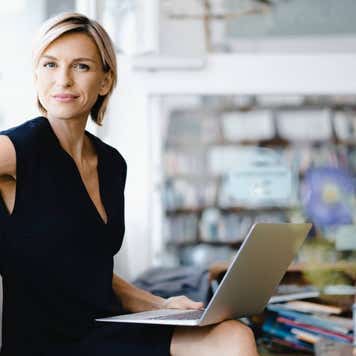 Person with open laptop on their lap.