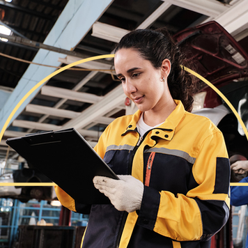 Female mechanic reading clipboard in garage