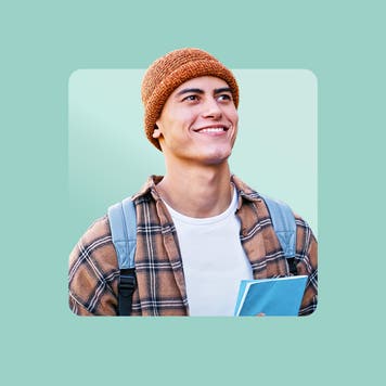 white male wearing orange beanie, flannel shirt over white t-shirt looking off into the distance