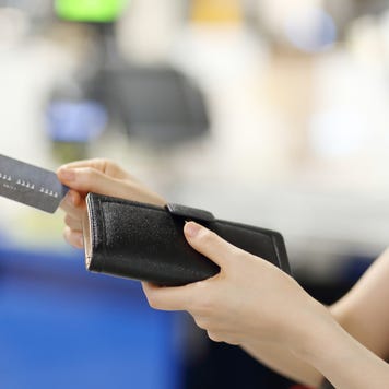 A woman holding a wallet and a credit card