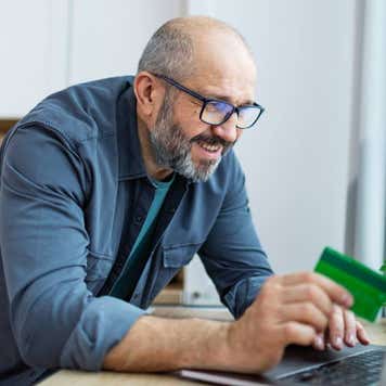 Man using laptop for online shopping, paying with credit card