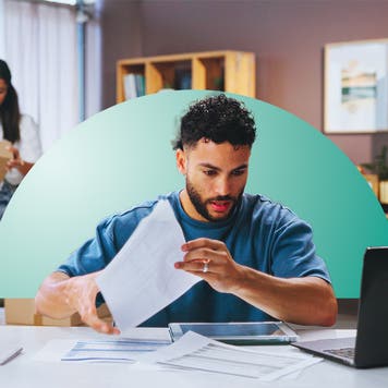 A man reviews papers and his laptop screen, with a teal half-circle design element behind him.